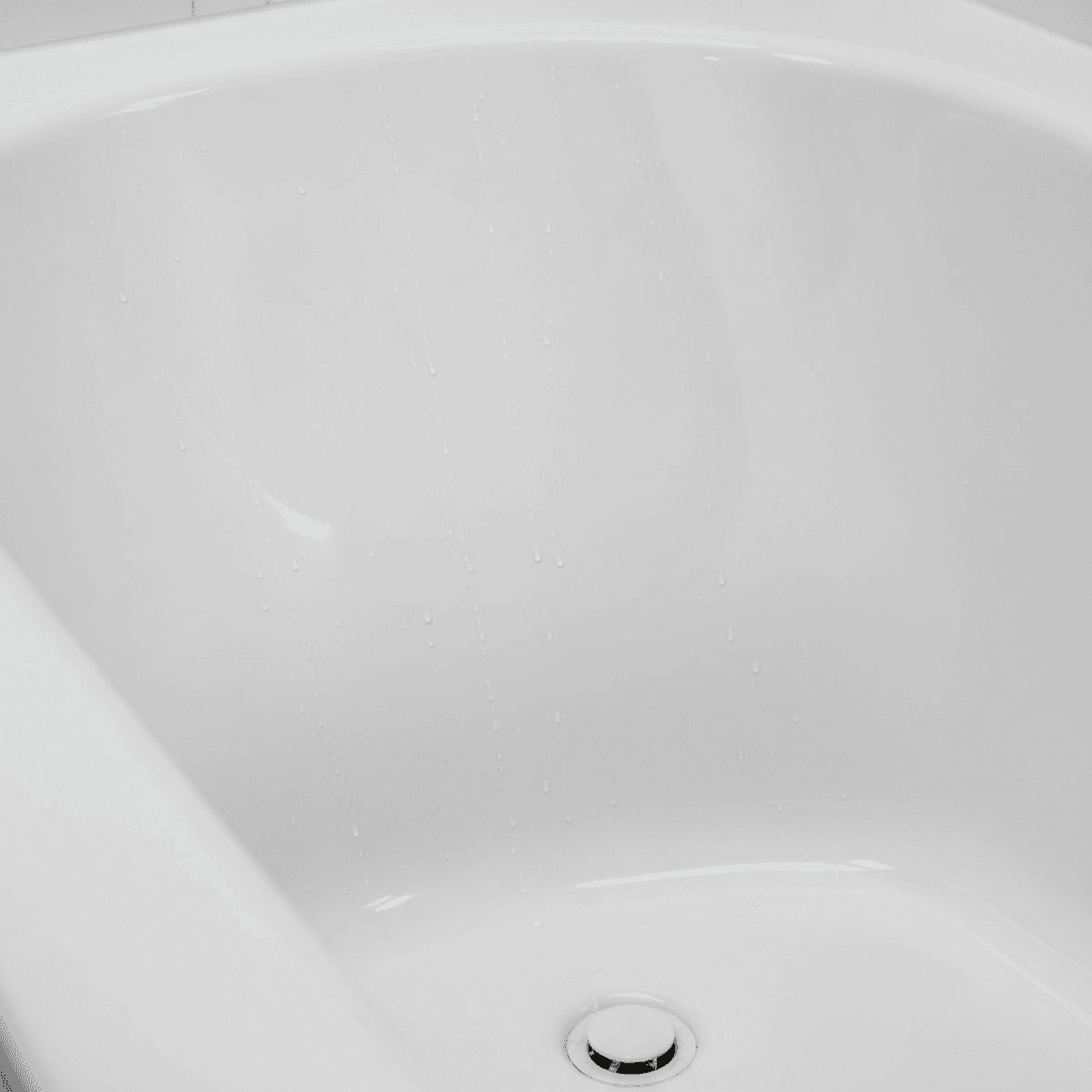 Close-up of a smooth glossy white bathtub surface after refinishing, showing a flawless finish